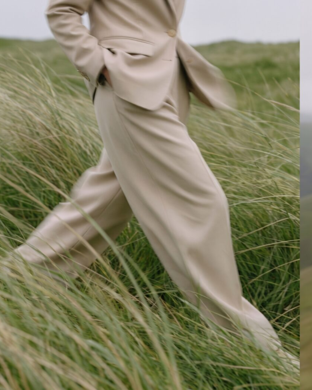 Neutral tailoring moving through a windswept field