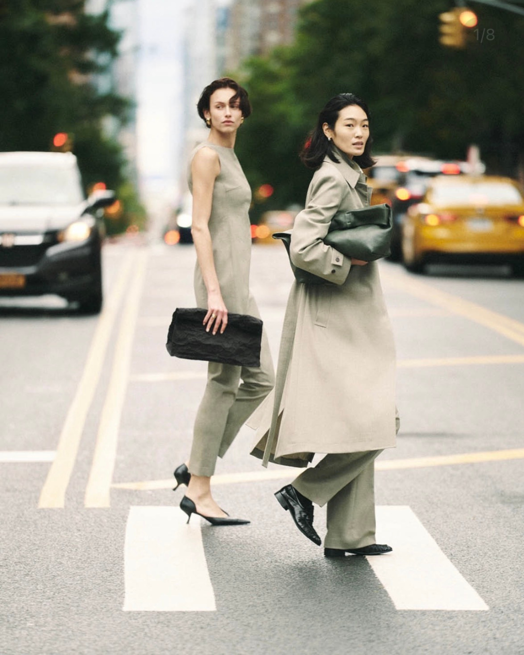 Two women in tailored looks crossing a city street