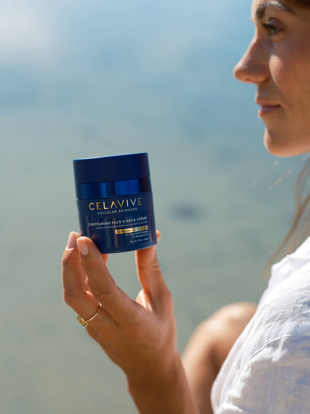 Celavive skincare cream held beside the sea